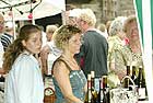 Mit strahlendem Gesicht beobachtet eine Winzerin das bunte Treiben auf dem Marktplatz von  am Rhein beim Weinfest, bei der Rotweinprobe im Juni und dem Rotweinfest im August.